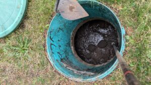 View inside a septic tank with wastewater and sludge visible.